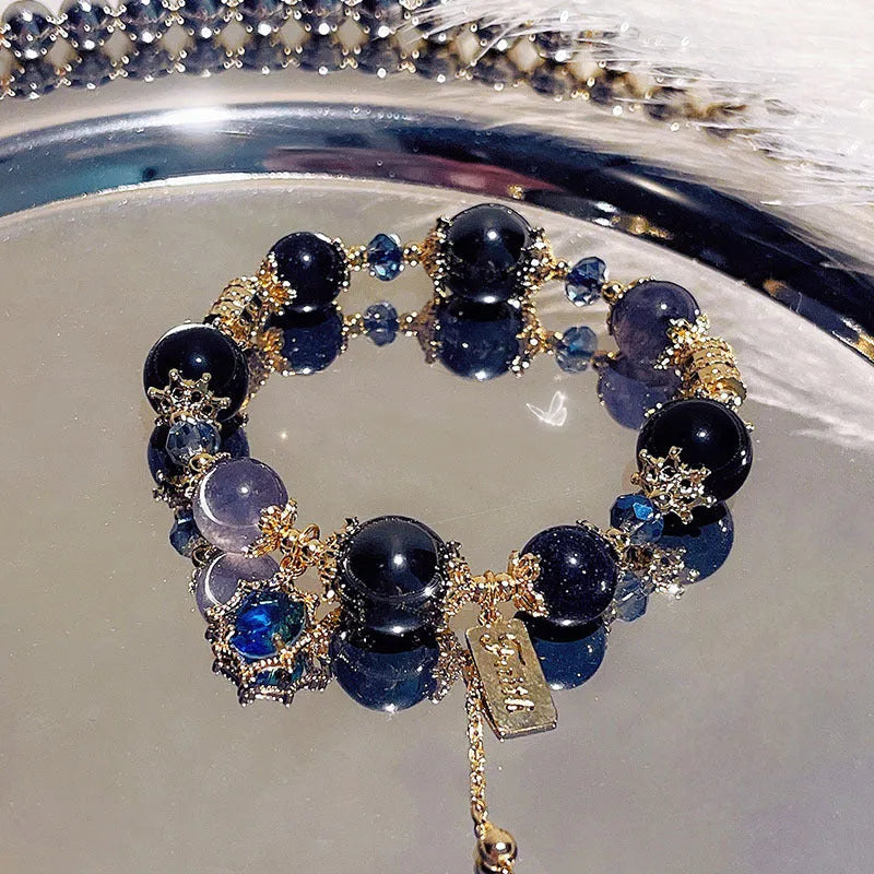 Galaxy-coloured alloy charm bracelet with snowflake, heart, and bow pendants.