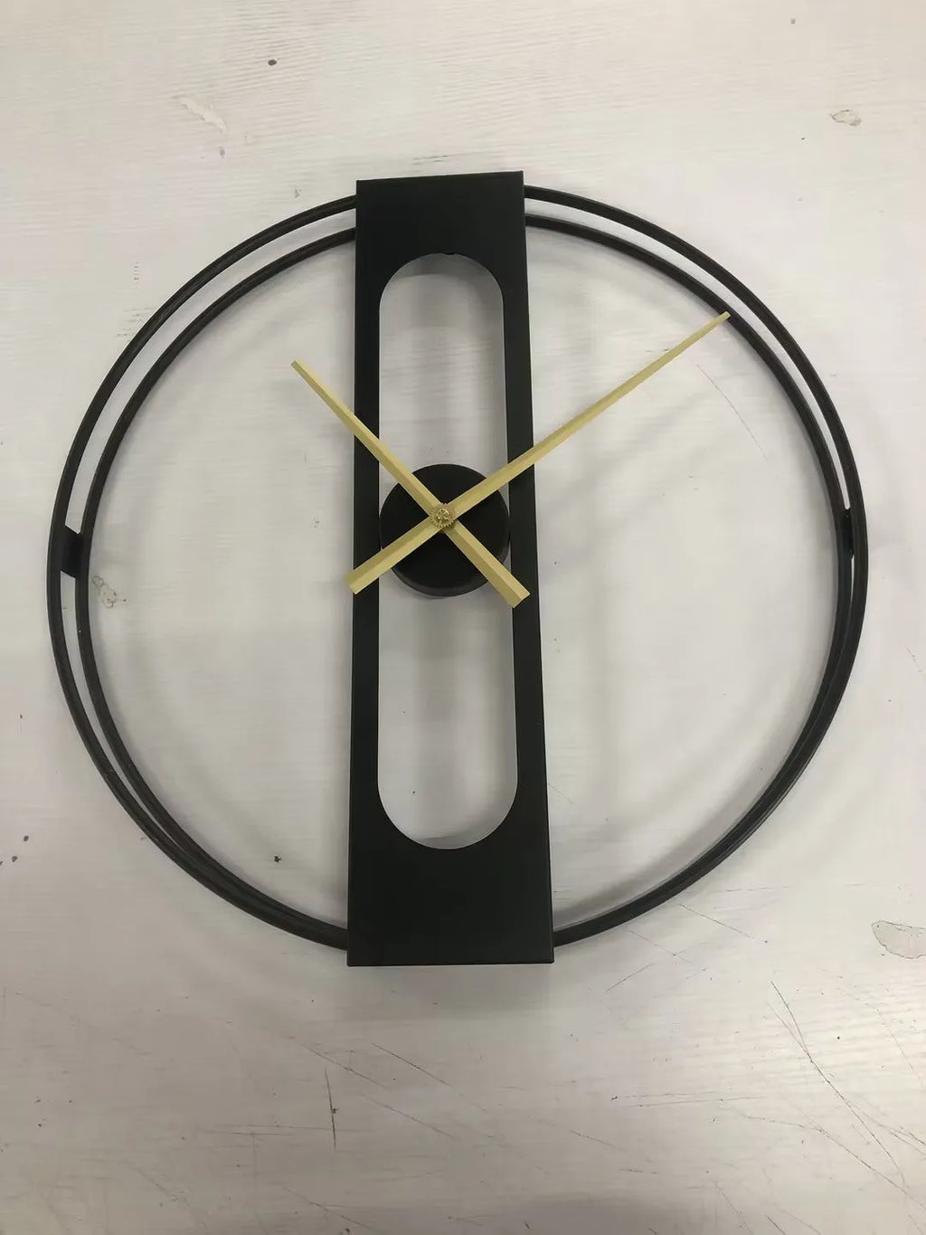 Round metal wall clock with 50 cm diameter in black or gold finish on a wall
