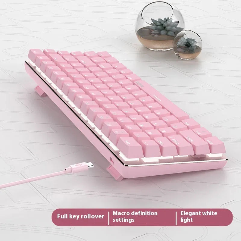 82-key mechanical keyboard with white backlight and metal housing beside laptop
