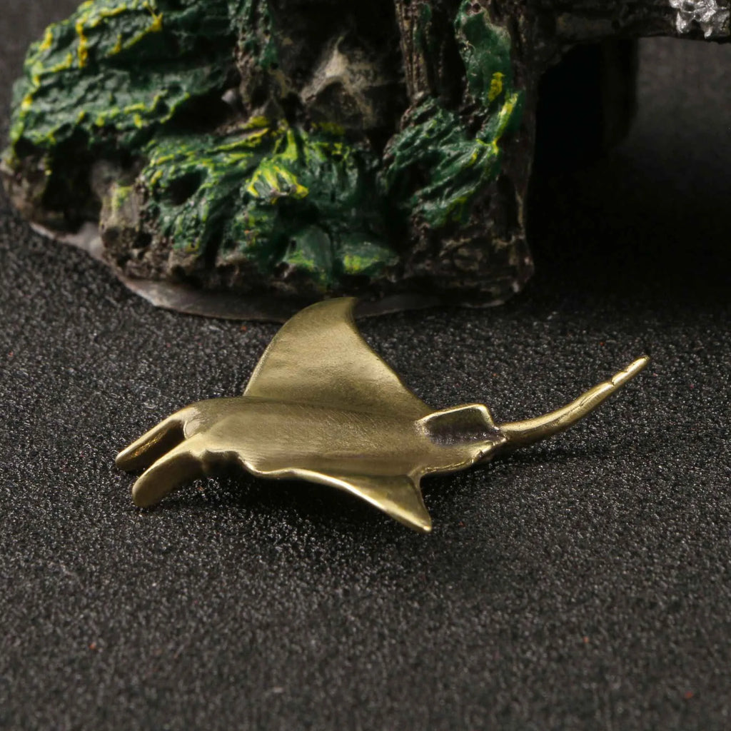 Brass devil fish ornament figurine on a surface, showing metallic colour and intricate devil fish design