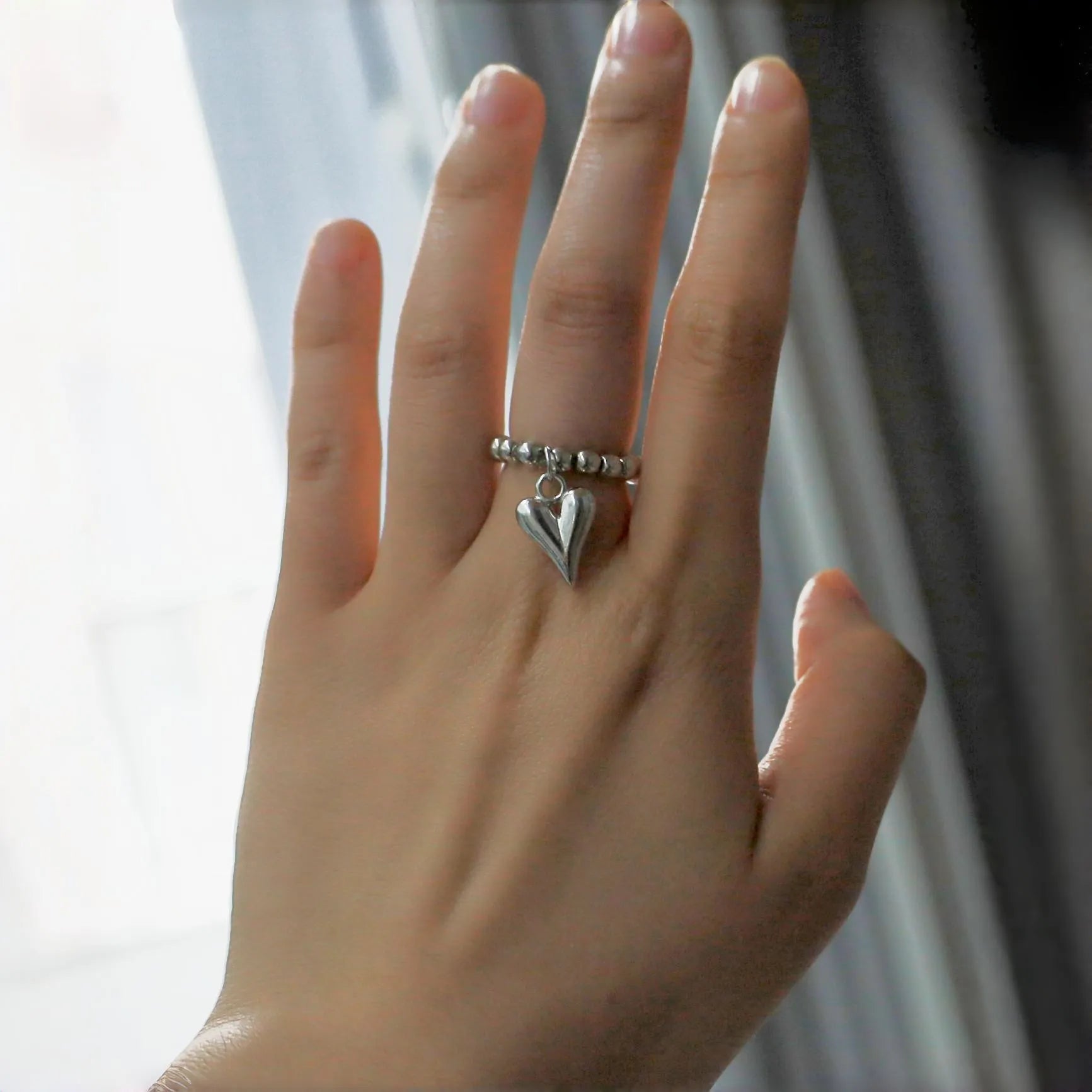 Handmade elastic love ring with geometric heart charm on beaded string