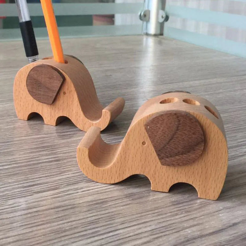 A creative desk mobile phone holder in beech wood or resin animal design with a coin slot.