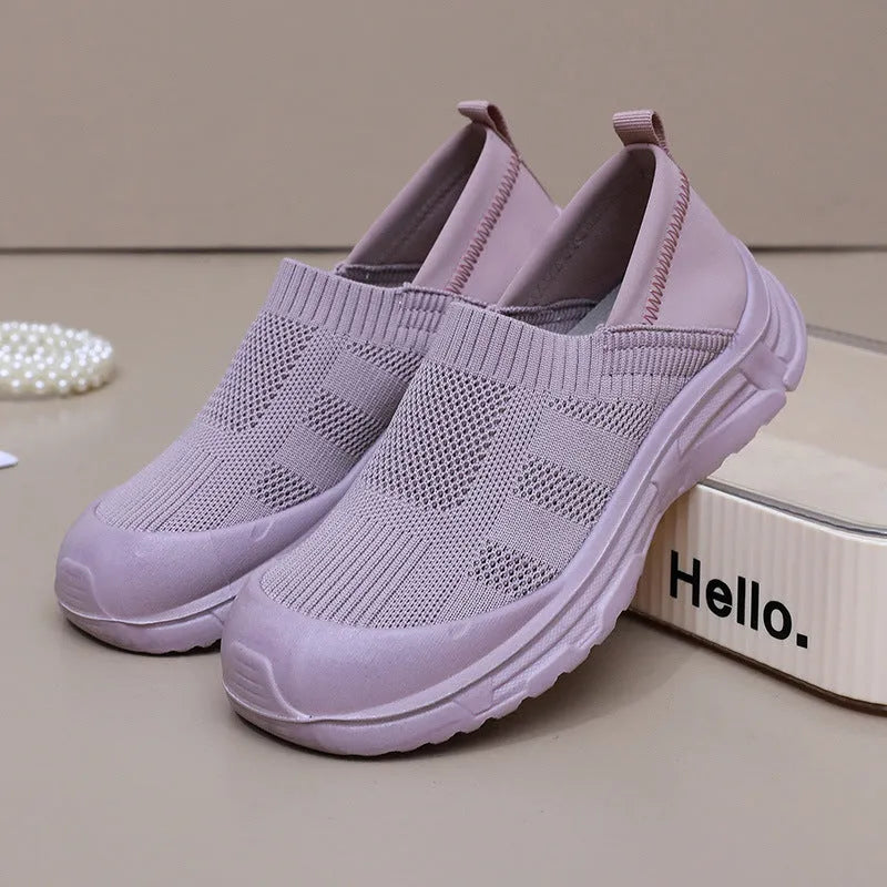 Women's beige, black and purple slip-on shoe covers with cloth upper and flat PVC sole.