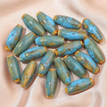 Assorted ceramic bullet beads in pink, yellow, blue, red, coffee, green, and orange colours