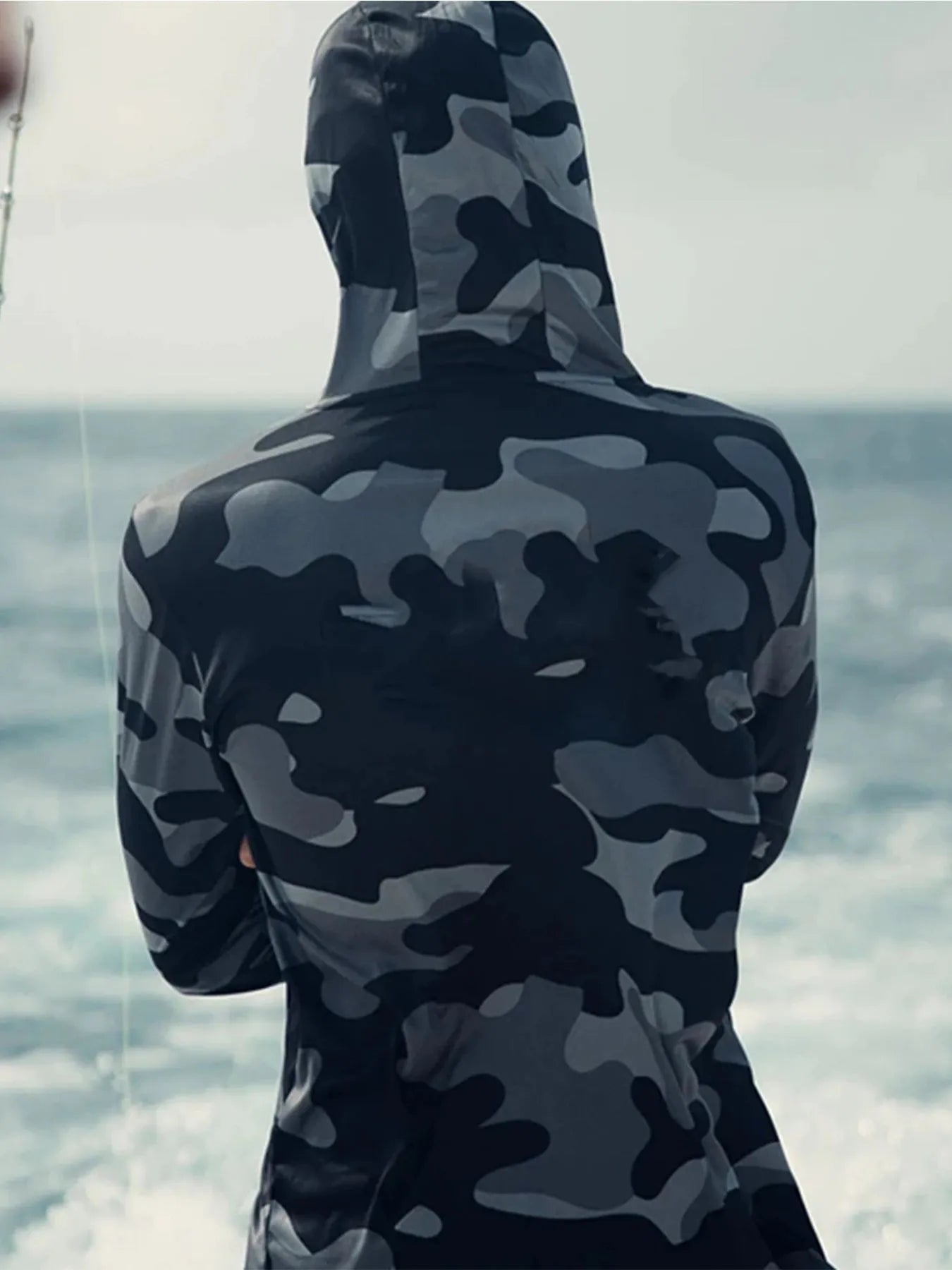 Huk Pursuit long sleeve performance fishing shirt with mesh side panels shown on a model.
