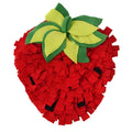 Red and green strawberry-shaped interactive slow feeder mat for pets on a floor.