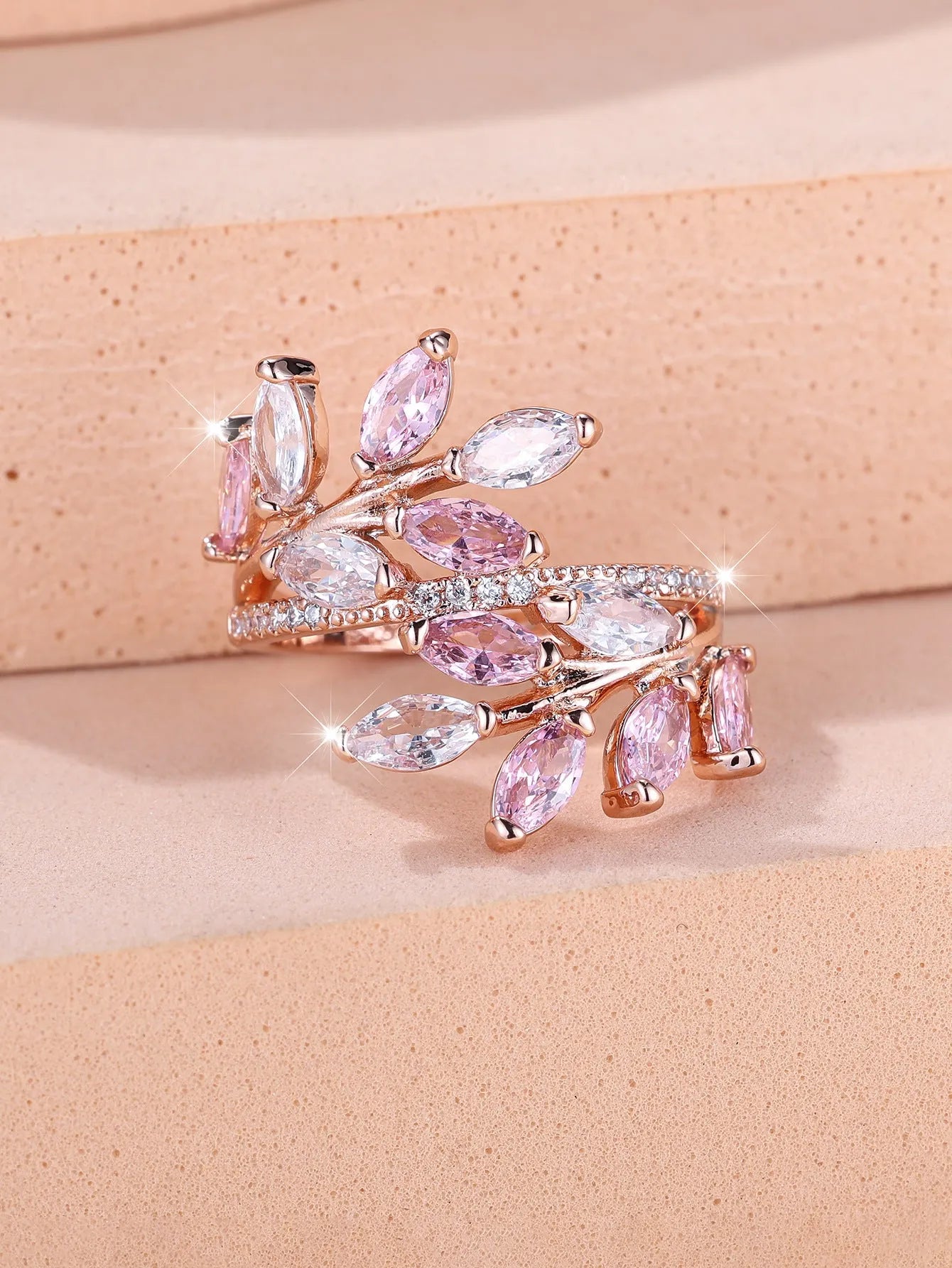 Adjustable open-ended leaf-shaped ring with zirconia stones on a copper band.