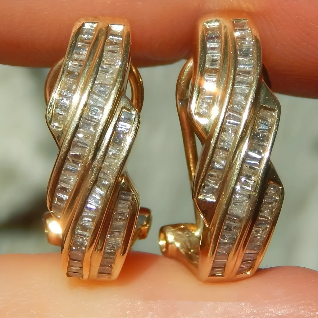 A pair of gold-coloured geometric round earrings made from copper on a plain background.