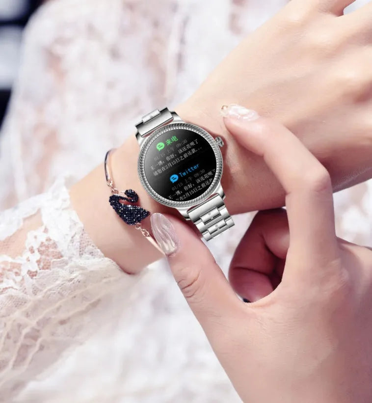 AK38 ladies smart watch with colour screen and stainless steel Milanese strap on a wrist.