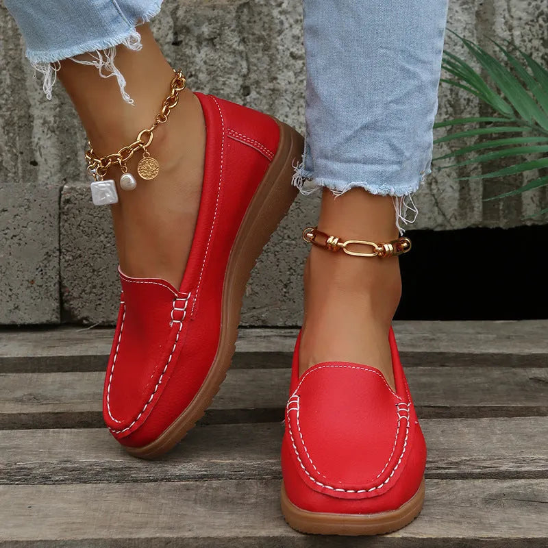 Women's flat PU leather loafers in multiple colours showing round toe and car suture detail.