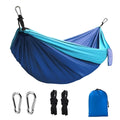 Blue nylon parachute cloth camping hammock hung between trees.
