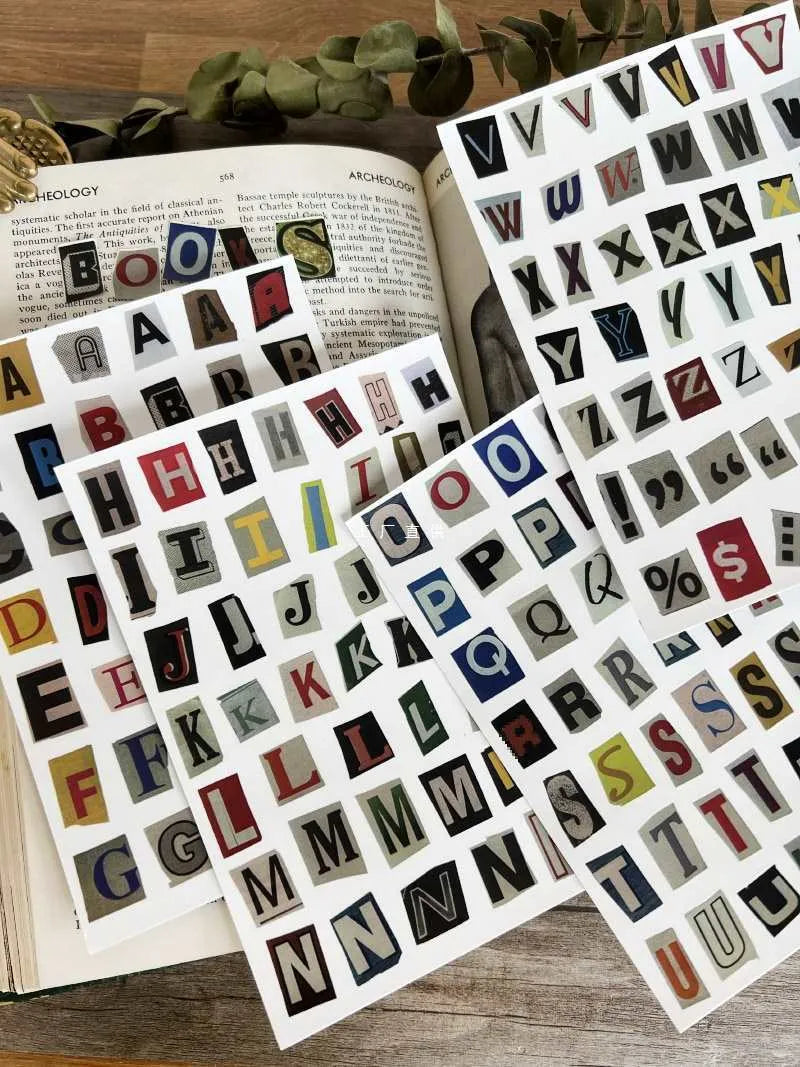 Sheets of cute printed stickers showing English letters A to Z, numbers, symbols, and weekly words like Monday and Friday.