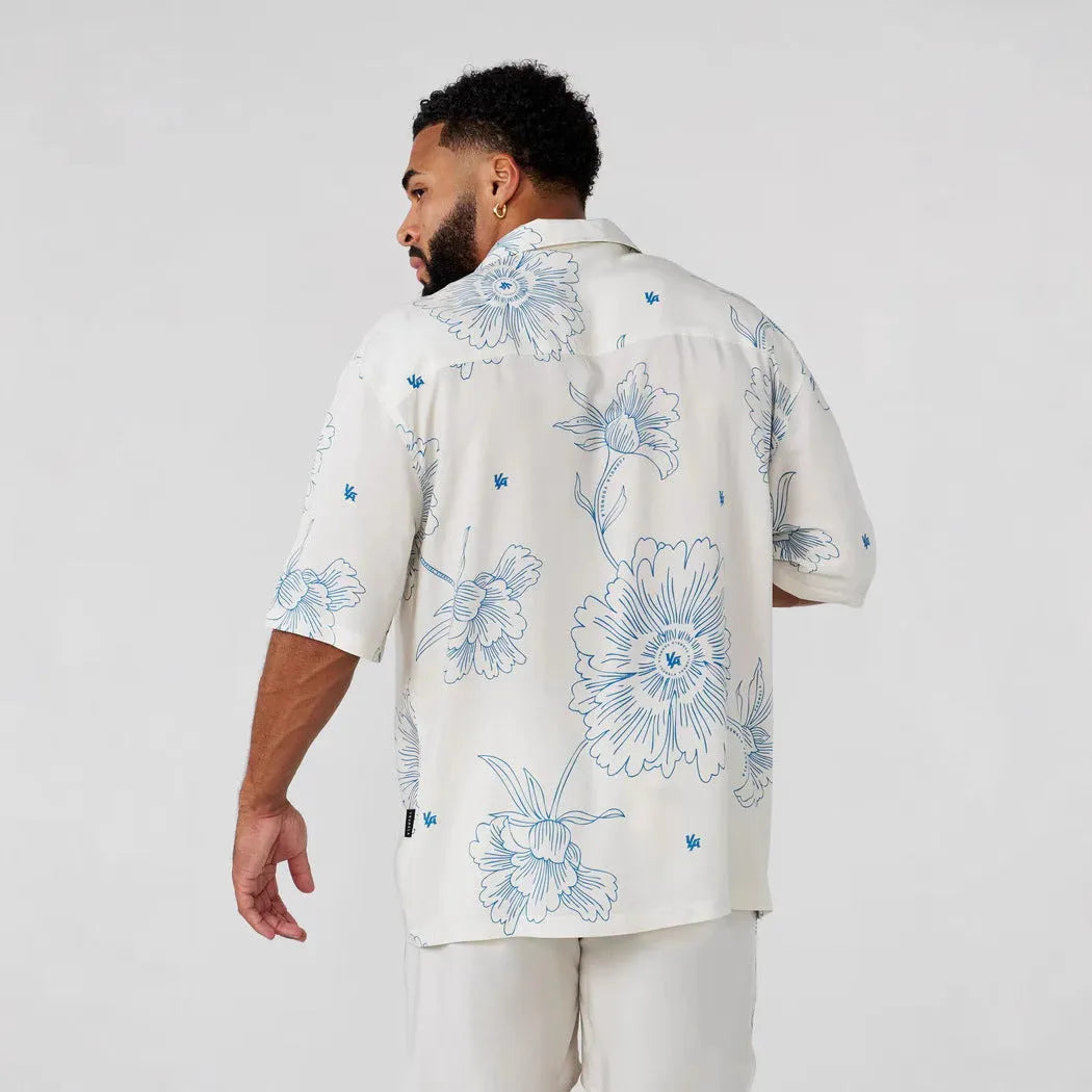 A loose-fitting short sleeve casual top with a floral print, shown in a light colour on a male model.
