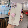 Green silicone iPhone case with a built-in screen protector and a white 3D flower spin stand on the back.