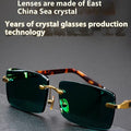 Dark green tinted frameless sunglasses with round lenses, shown with a glasses case and cleaning cloth.