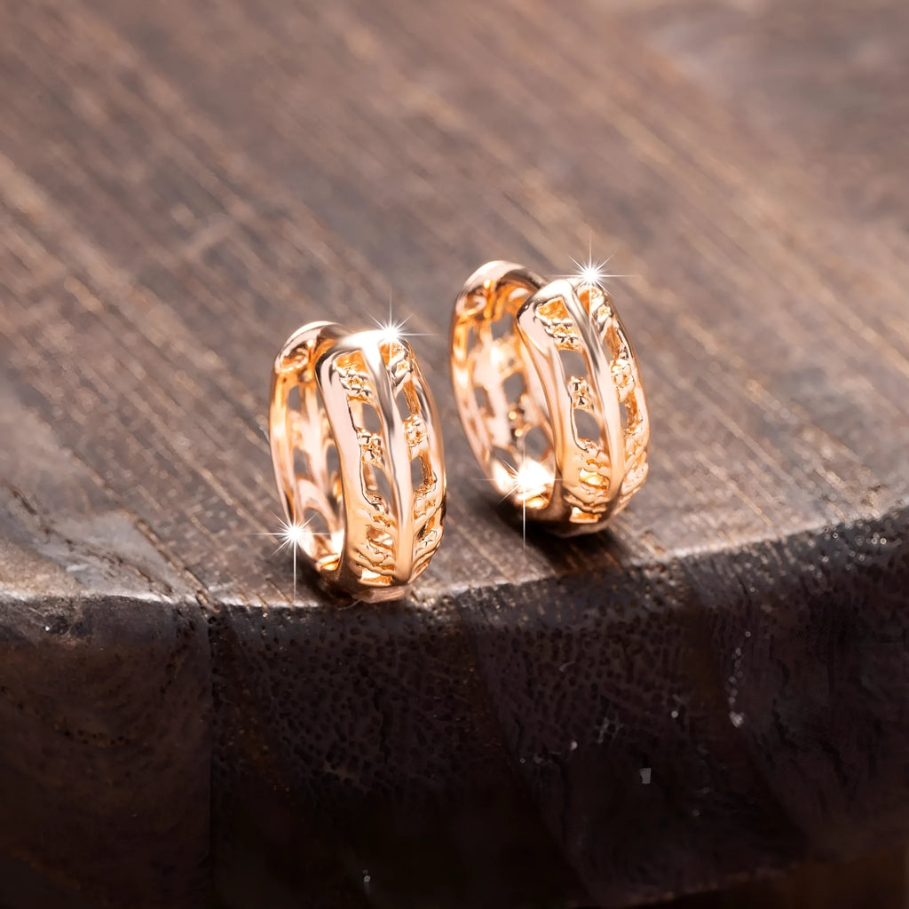 Rose gold coloured copper earrings with hollowed-out leaf and heart shapes.