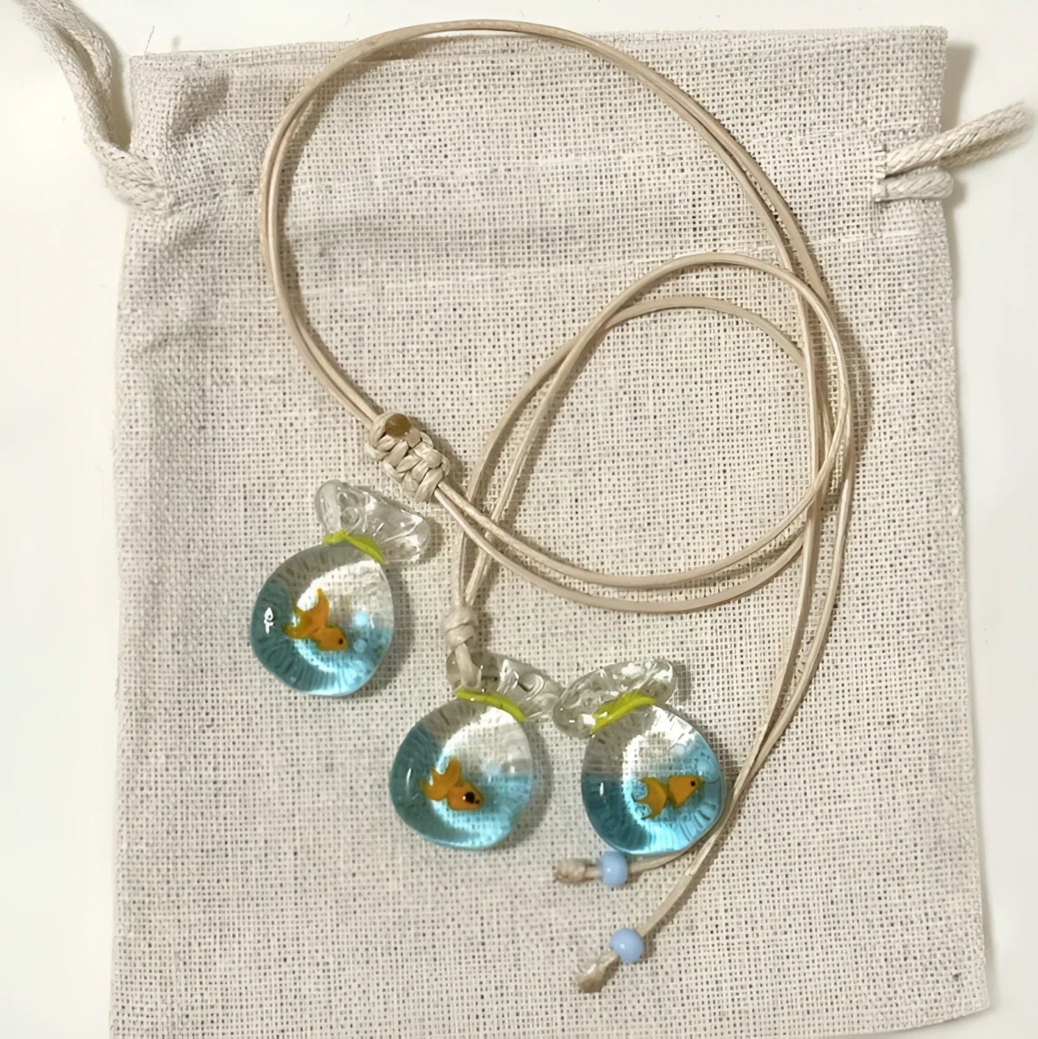 Women's world style necklace with coloured glaze joker pendant on a cotton linen clavicle chain.