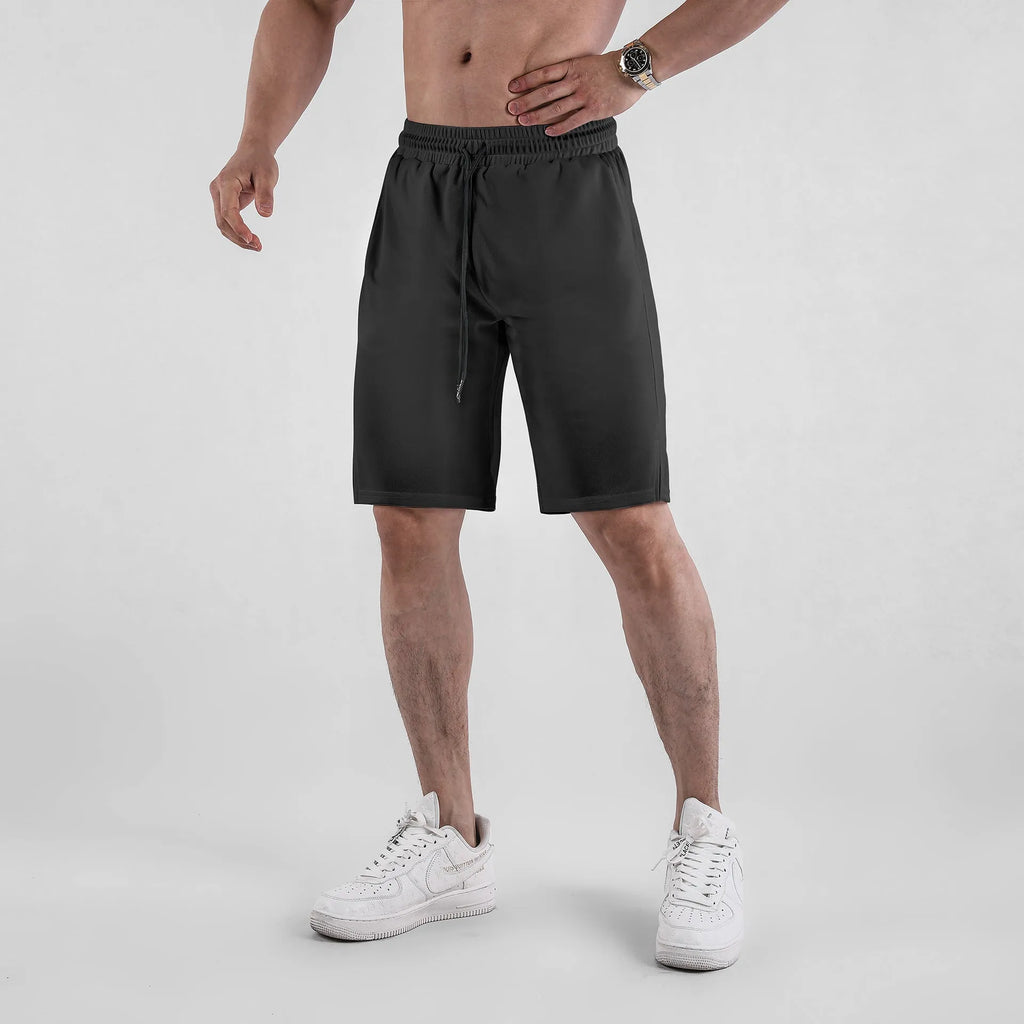 Man wearing loose-fitting black quick-dry mesh fitness shorts with an elasticated waistband.