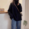 Women's loose grey turtleneck sweater with a thick 3D patterned texture and curling collar.