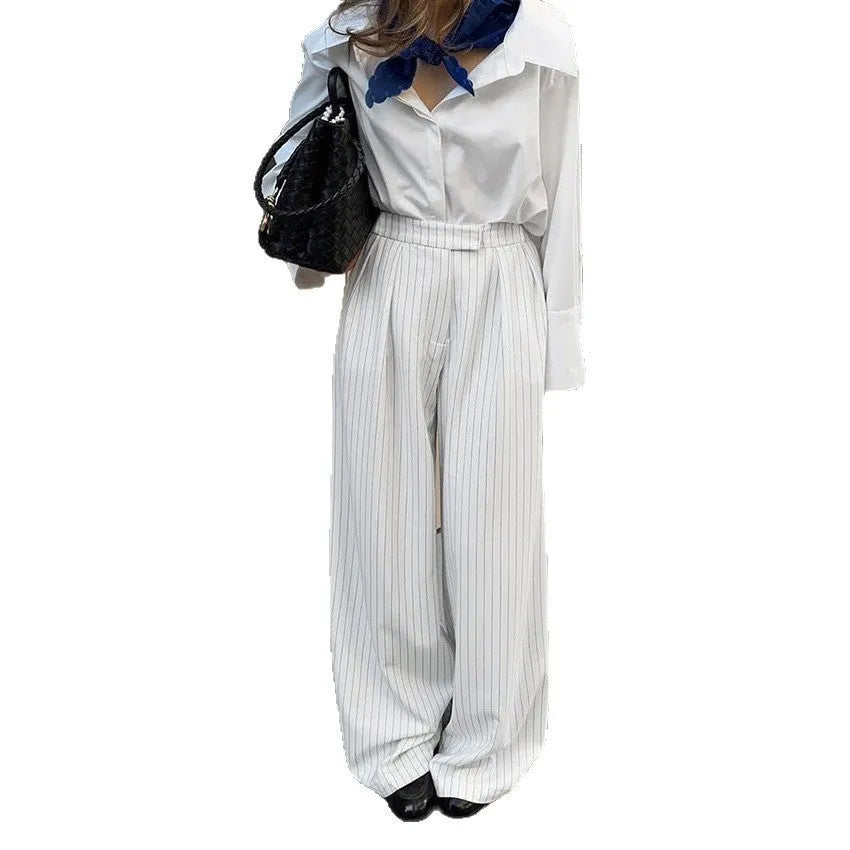 White wide-leg trousers with vertical stripes, featuring a loose casual fit and a front zipper fastening.