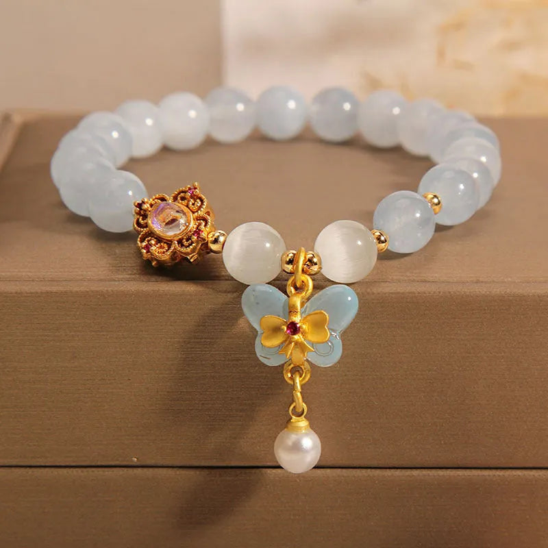 Women's crystal bracelet with aquamarine butterfly pendant and rhinestone detailing.