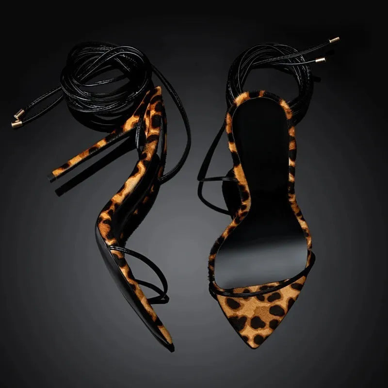 Women's leopard print Roman sandals with a pointed toe and lace-up buckle strap on a rubber sole.