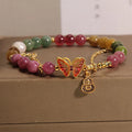 Women's agate and tourmaline bracelet with a detailed butterfly-shaped gourd charm in natural jade colours.