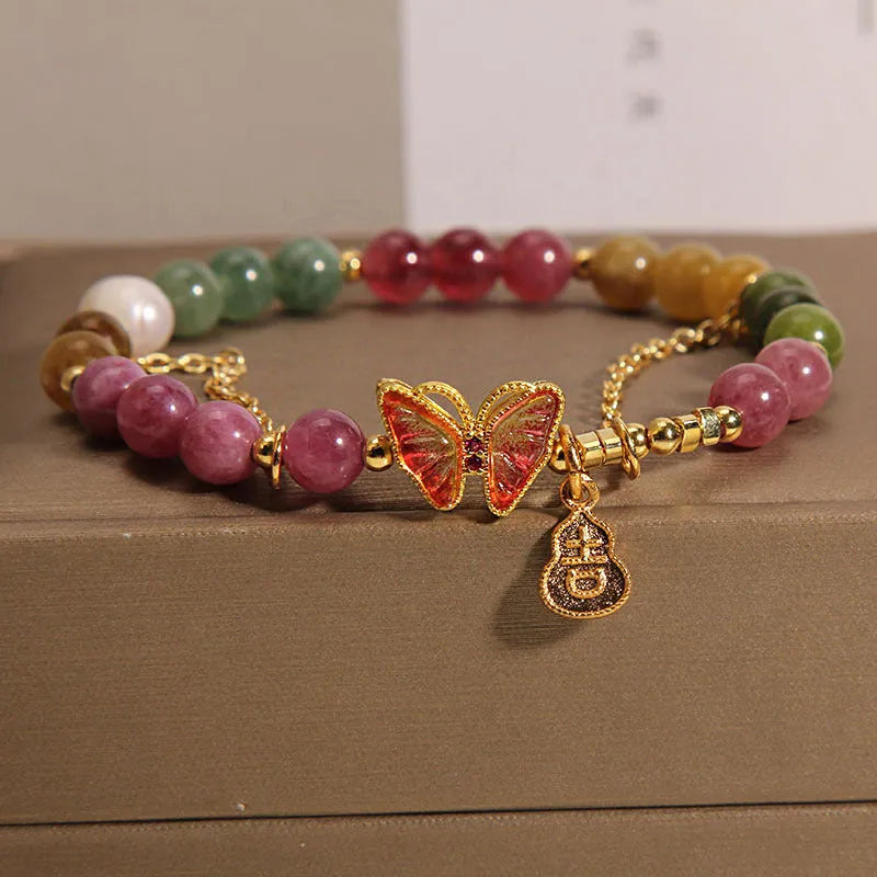 Women's agate and tourmaline bracelet with a detailed butterfly-shaped gourd charm in natural jade colours.