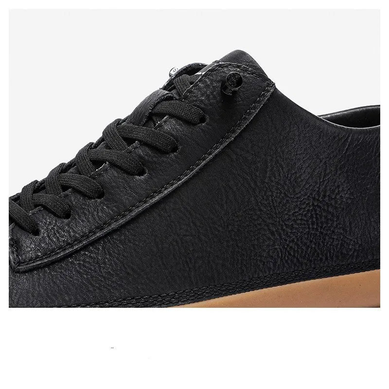 A pair of black men's round-toe casual leather shoes with white laces on a flat rubber sole.