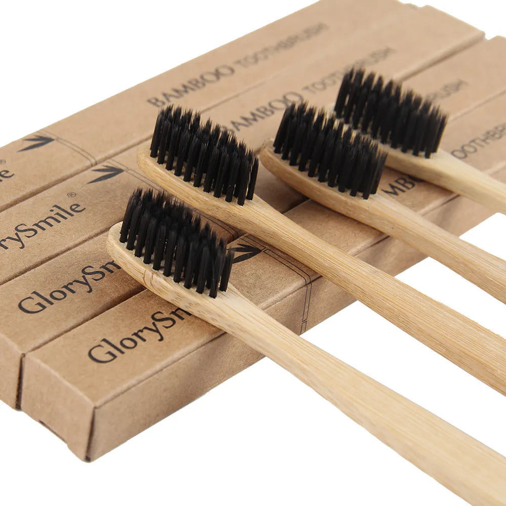 Natural pure bamboo toothbrush with black charcoal-infused bristles on a light background