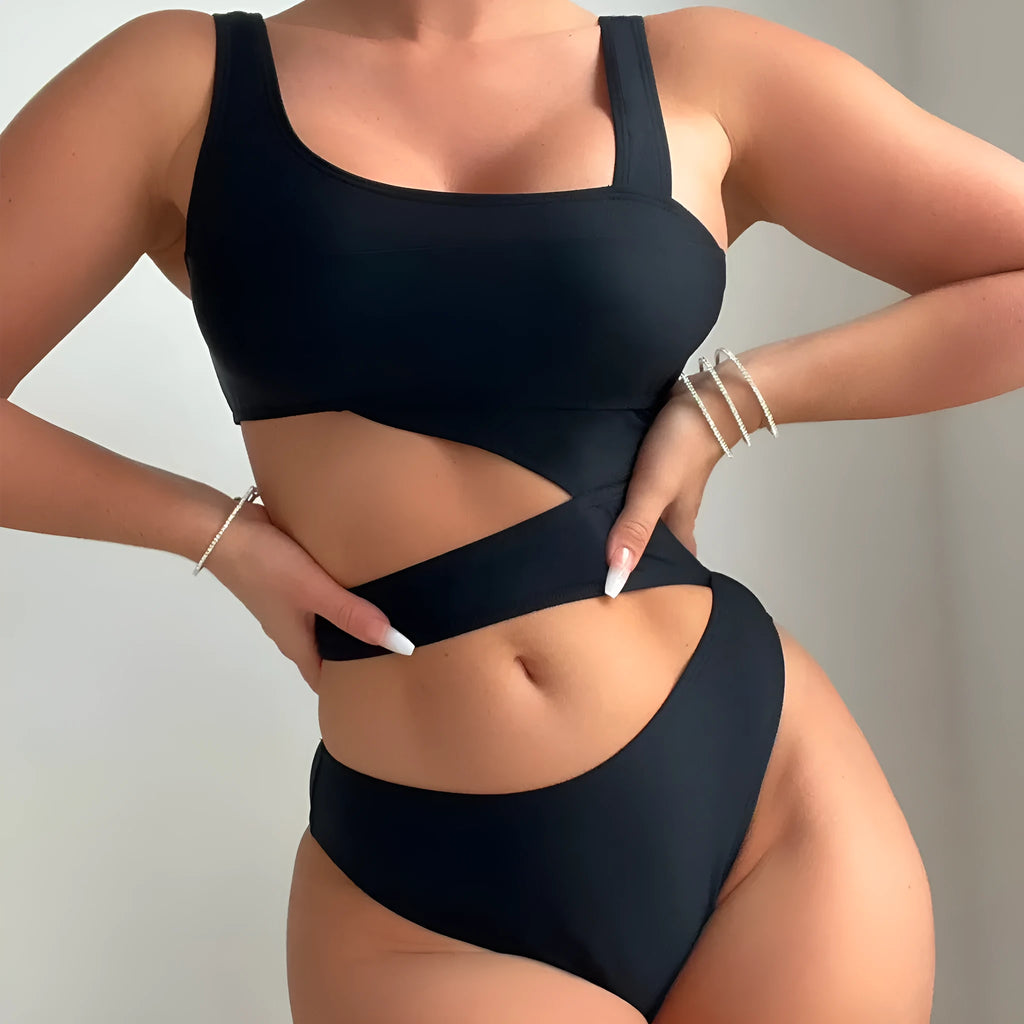 Black hollow high cut one-piece swimsuit on hanger showing sleeveless design