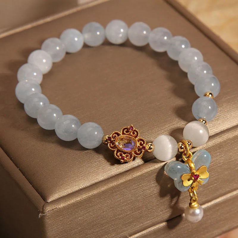 Women's crystal bracelet with aquamarine butterfly pendant and rhinestone detailing.