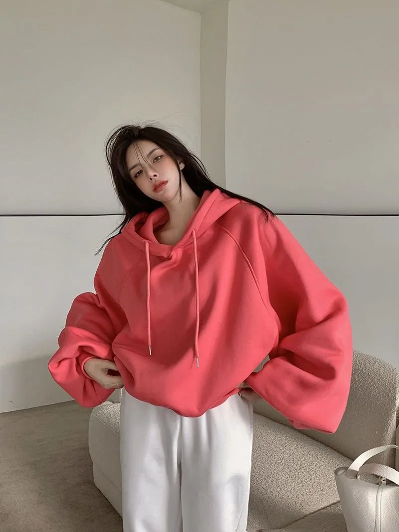 Women's loose watermelon red mulberry silk hooded pullover sweater on a hanger.