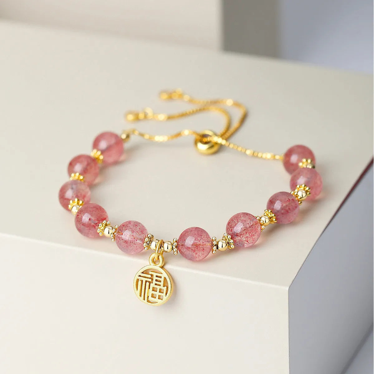 Strawberry quartz crystal bracelet with geometric shapes and fu character symbols
