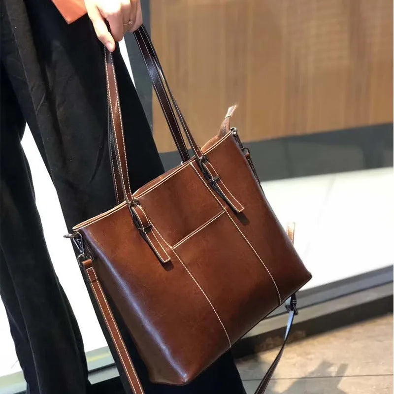 Brown genuine leather retro women's shoulder bag with three straps showing interior organisation compartments