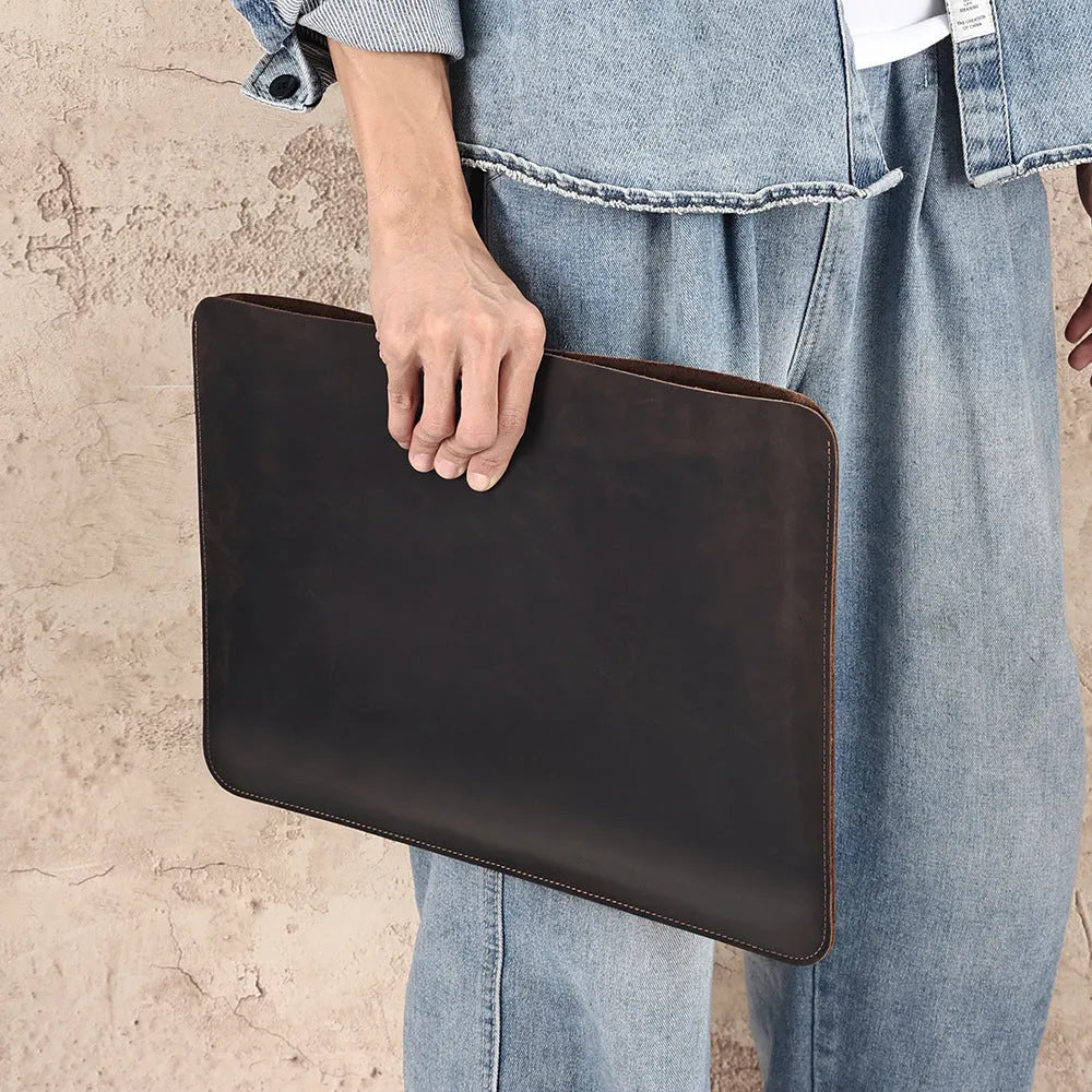 Brown horizontal computer liner bag made from cowhide leather showing laptop storage compartment