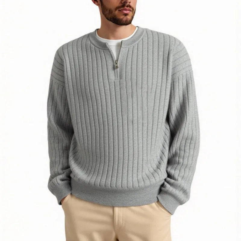 Man wearing a grey textured knit half-zip sweater with a loose fit and long sleeves.