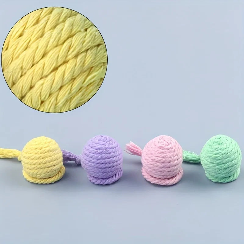 Cat toy ball with integrated rope and bell in green pink purple yellow colours