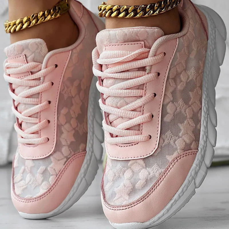 Women's white canvas running shoes with flat heel and round toe on a light background.