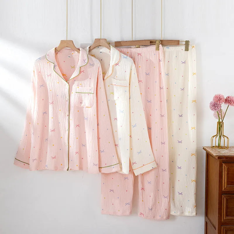 Women's pink cotton pajama set with long sleeves and full-length trousers on hanger