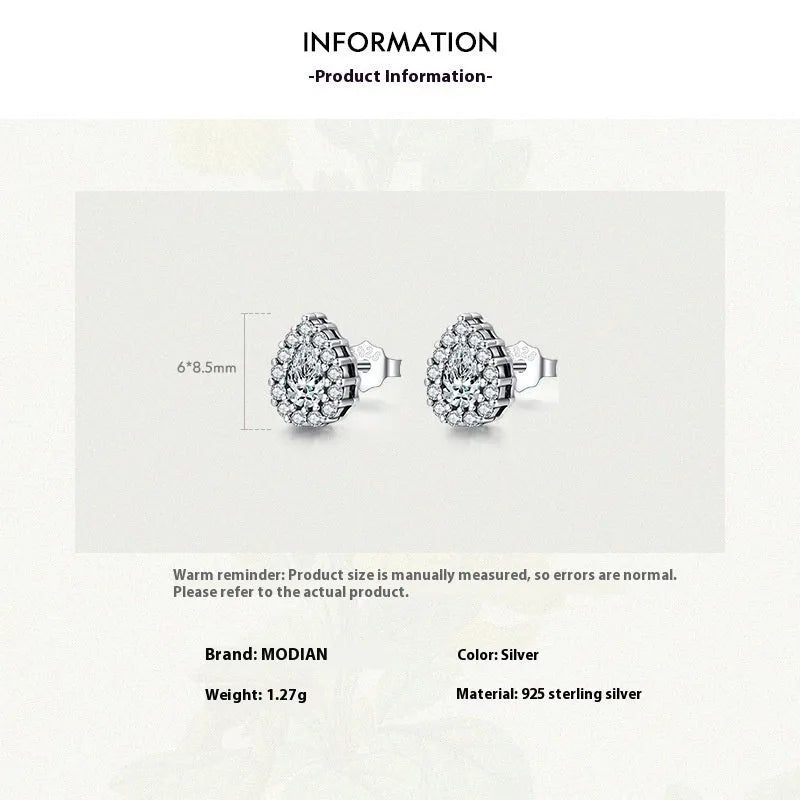 Close-up of a pair of women's silver water drop shaped ear studs on a plain background.