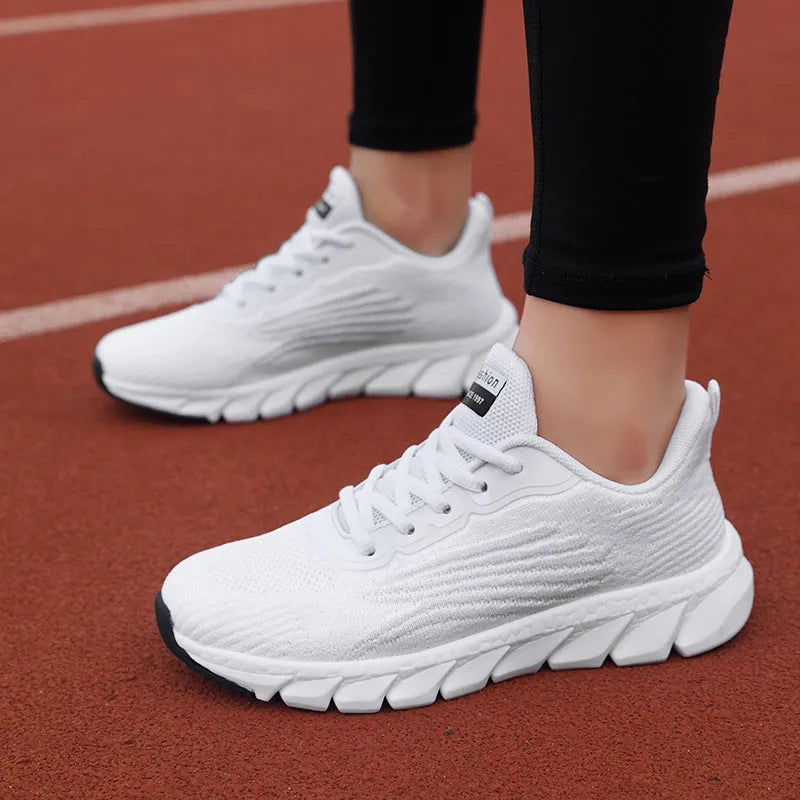 Women's black and white running shoes with cross strap detail and MD shock absorption sole