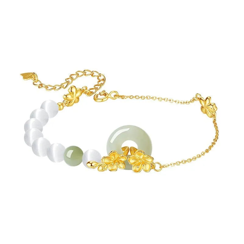 Women's pure silver bracelet with a safety buckle and a peach blossom flower charm in a choice of gold colours.
