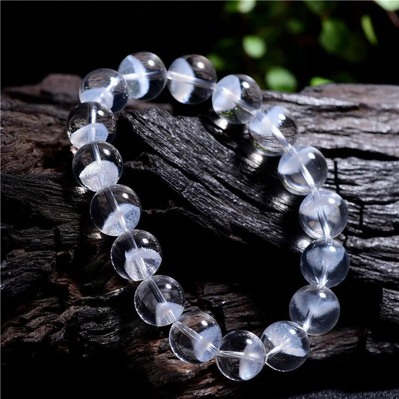 Women's white crystal pyramid bead ghost bracelet with a Ruyi charm on a white background.