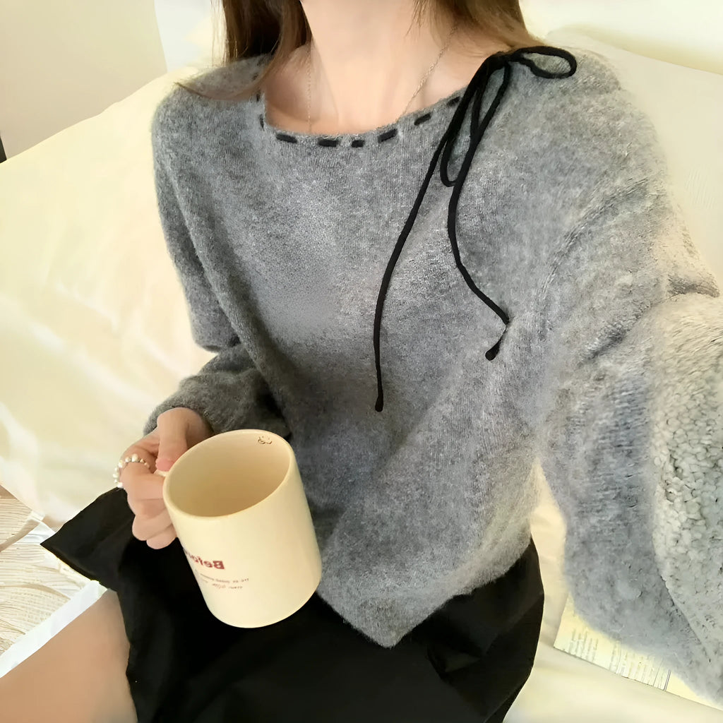 Grey loose-fit women's knit pullover top on a hanger.
