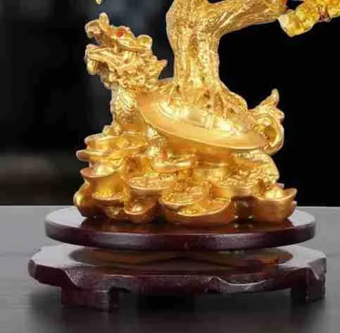 Citrine coloured resin small water turtle money tree Feng Shui ornament on a surface.