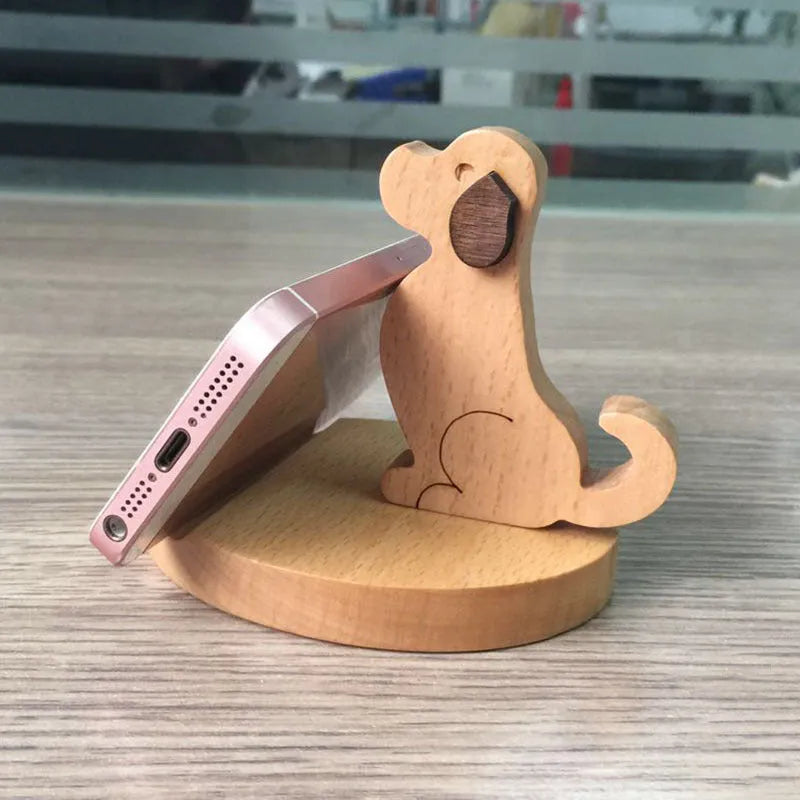 A creative desk mobile phone holder in beech wood or resin animal design with a coin slot.