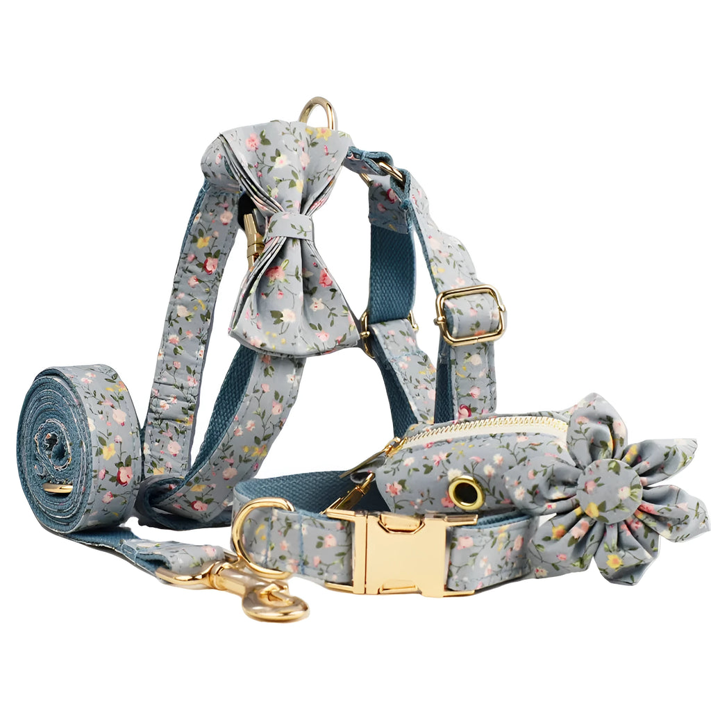 Blue floral patterned dog collar and matching leash, bow, vest, and poop bag set on a white background.