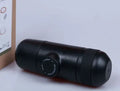 Black portable manual coffee machine showing compact 6cm design with pressure system for travel brewing