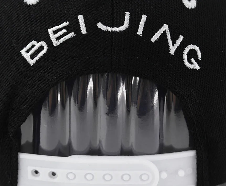 Cotton baseball hat with embroidered lettering in black colour showing adjustable strap